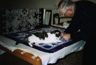 Photo of Jake and Grandpa pin basting a quilt