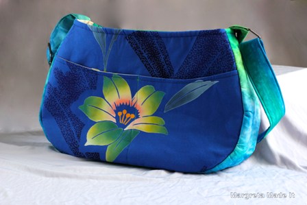 Asian inspired purse with extendable strap and multiple pockets for storing and carrying items.