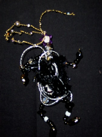 Party Pat wearable art brooch in black and silver fibers, black beads. Party Pat is ready to go to any party in her black and silver outfit.
