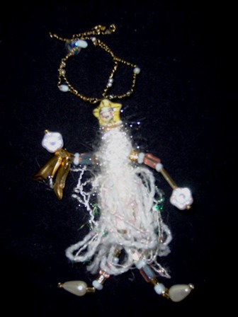 Runaway Bride wearable art brooch in white fibers and white and gold beads with a pair of charm shoes in her hand.