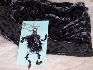 Party Pat wearable art pin in black and silver teamed with a black scarf
