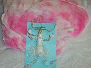 Suzy Snowflake wearable art pin in whites and ice blues teamed with a pink and white short scarf